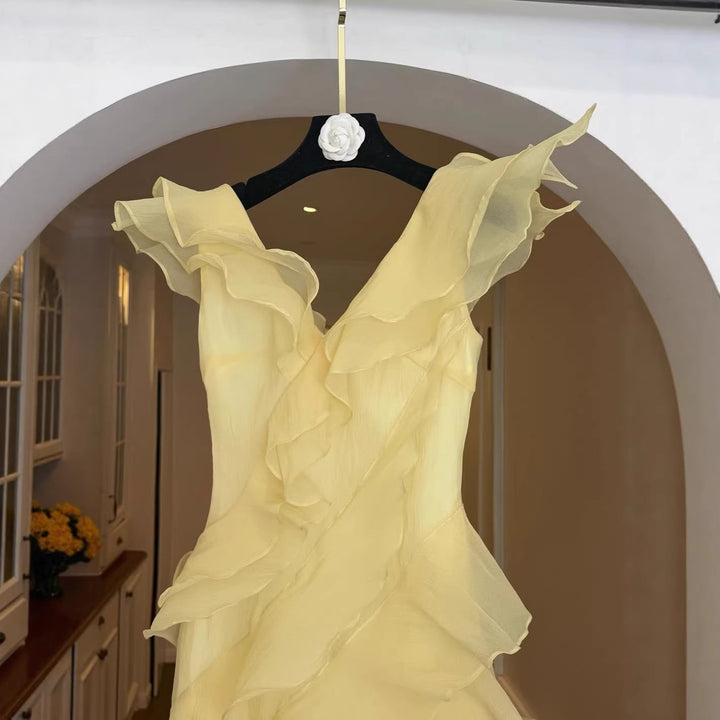 Sofistikert lysegul off-shoulder damekjole med volang. En elegant festkjole eller bryllupsgjestkjole.