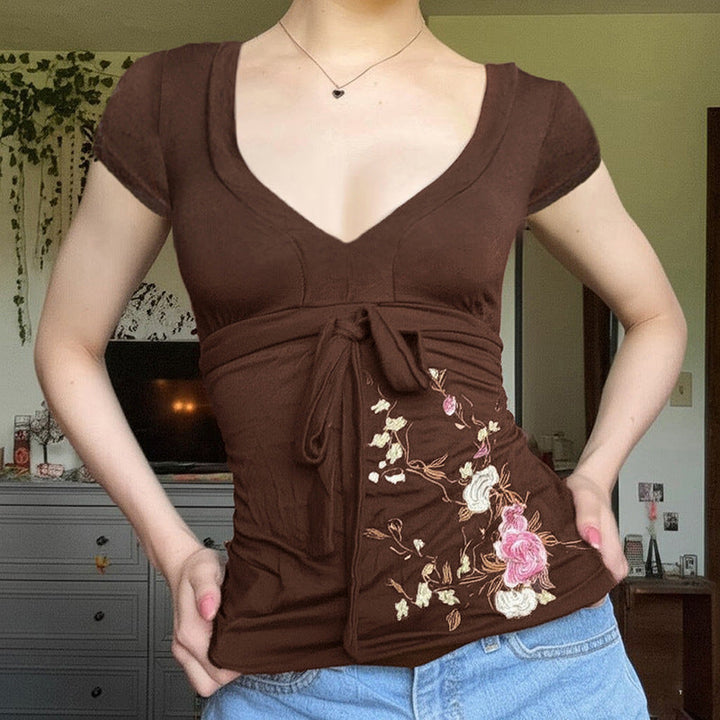 Brun dame blyantkjole med elegant blomsterbroderi, V-hals og flatterende draperingsdetaljer.