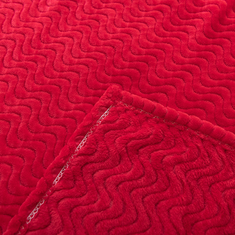 Detalj av mykt, rødt bølgeteppe som viser unik tekstur og luksuriøs følelse, perfekt for koselige kvelder.