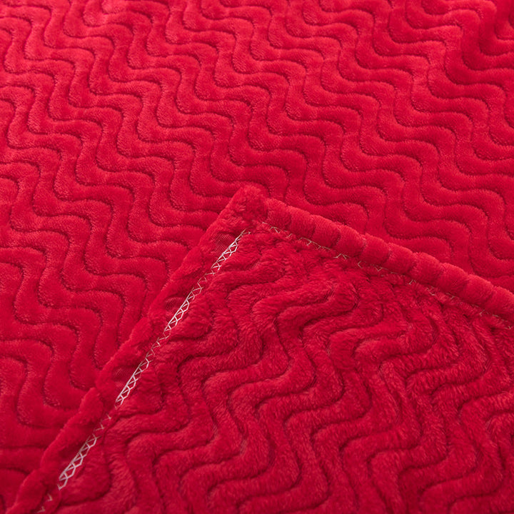Detalj av mykt, rødt bølgeteppe som viser unik tekstur og luksuriøs følelse, perfekt for koselige kvelder.