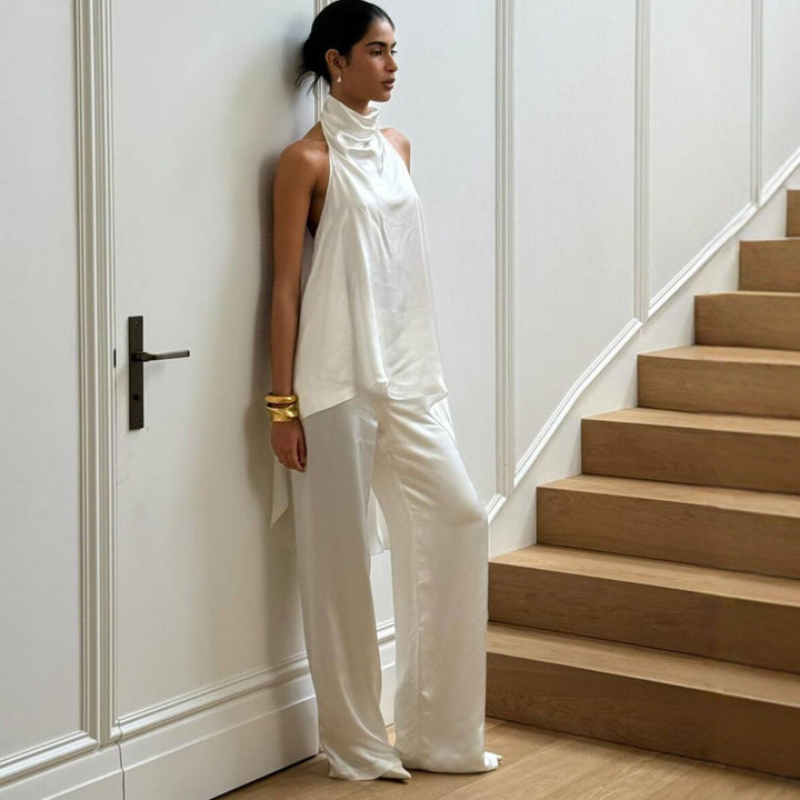 Trendy dame jumpsuit i hvit med asymmetrisk halslinje og stående krage. Sofistikert og formell look.