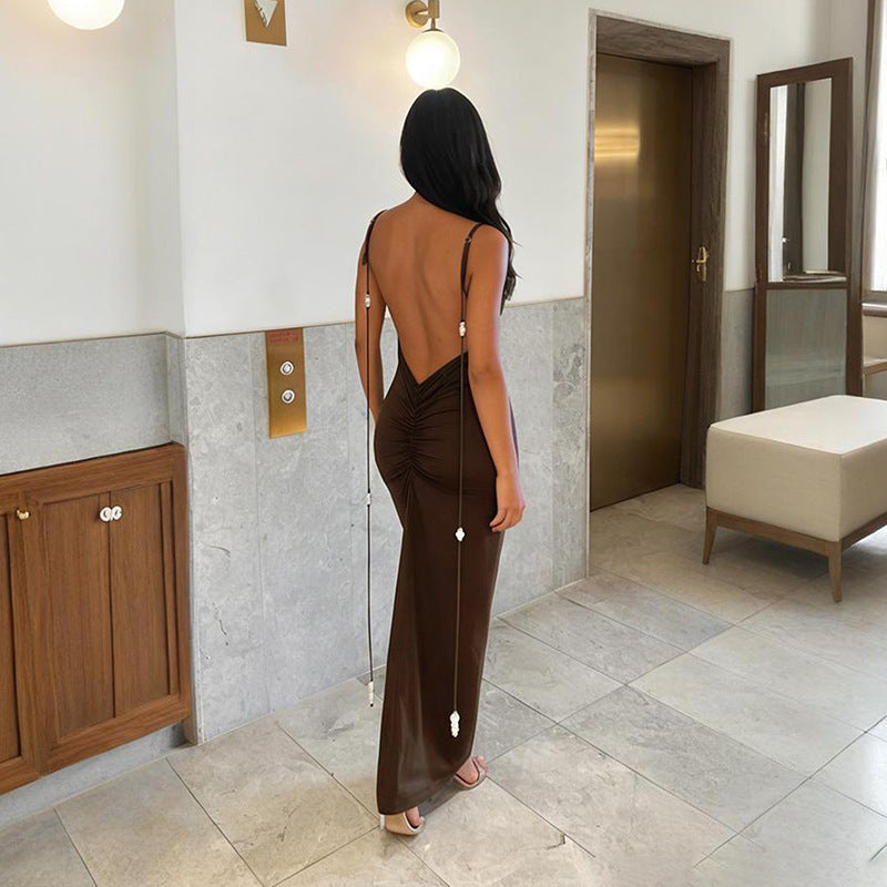 Kvinner elegant maxikjole, vist bakfra. Dyp rygg med subtile volanger. Ideell for formelle begivenheter og sommerfester.