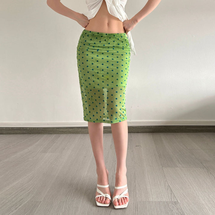 Luftig grønt dameskjørt med prikker, volanger og gjennomsiktig kant. Trendy motestil for sommer.