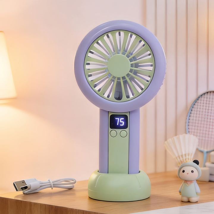 En person bruker en kompakt, oppladbar håndvifte i rosa med LED-skjerm for å holde seg kjølig ute om sommeren.