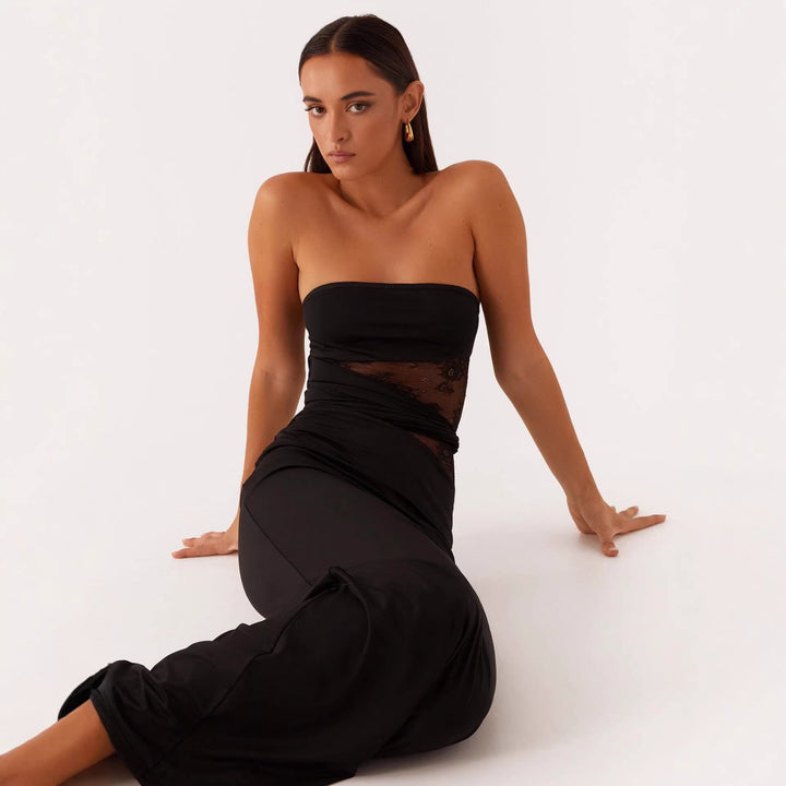 Figursydd svart damekjole sett fra siden, fremhever slank silhuett og elegant fall, ideell som festkjole.