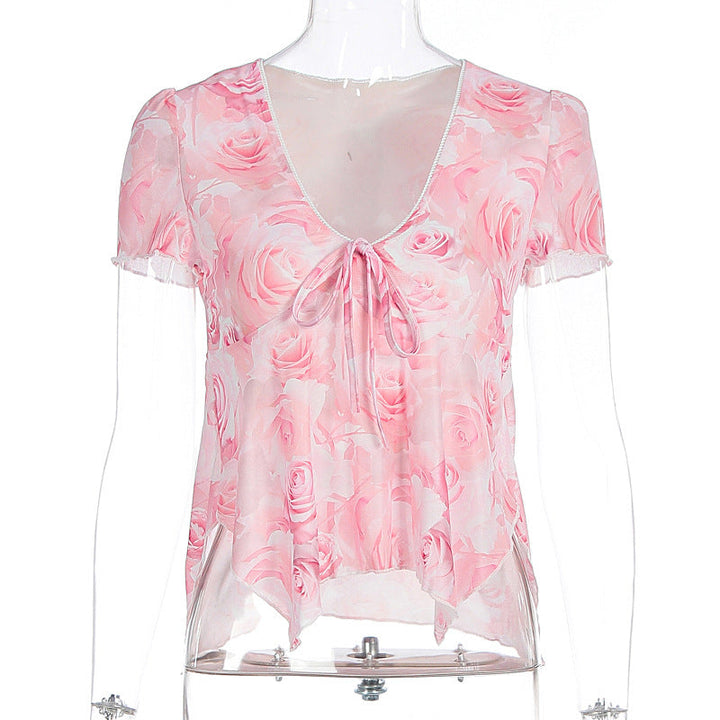 Nærbilde av elegant damebluse, viser intrikat rosemønster, stoff og justerbart knytebelte. Kvalitets kvinneklær.