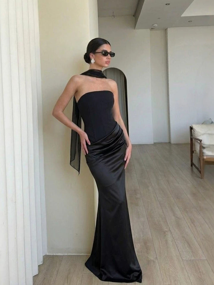 Svart damekjole med bodycon passform og utsøkt drapering, perfekt for glamorøse anledninger og feiringer.
