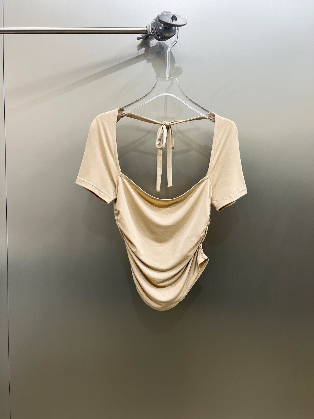 Khaki stretchbluse for dame, langermet, med elegant ryggutskjæring. Komfortabel og stilfull hverdags- eller festtopp.