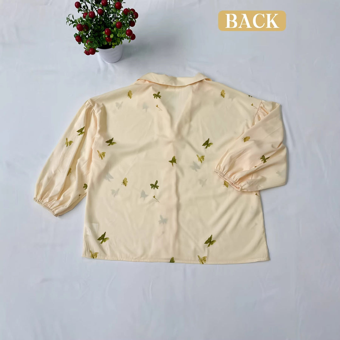 Elegant gul kvinnebluse med volangdetaljer og broderte blomster, ideell for alle anledninger.