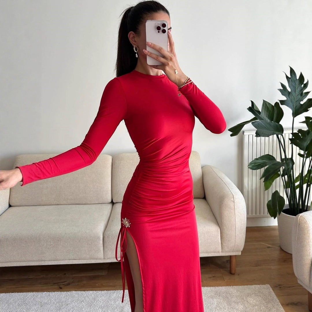 Elegant lang damekjole i rød eller svart, med figurnær silhuett, rynker og et sexy høyt splitt. Flott kveldsantrekk.