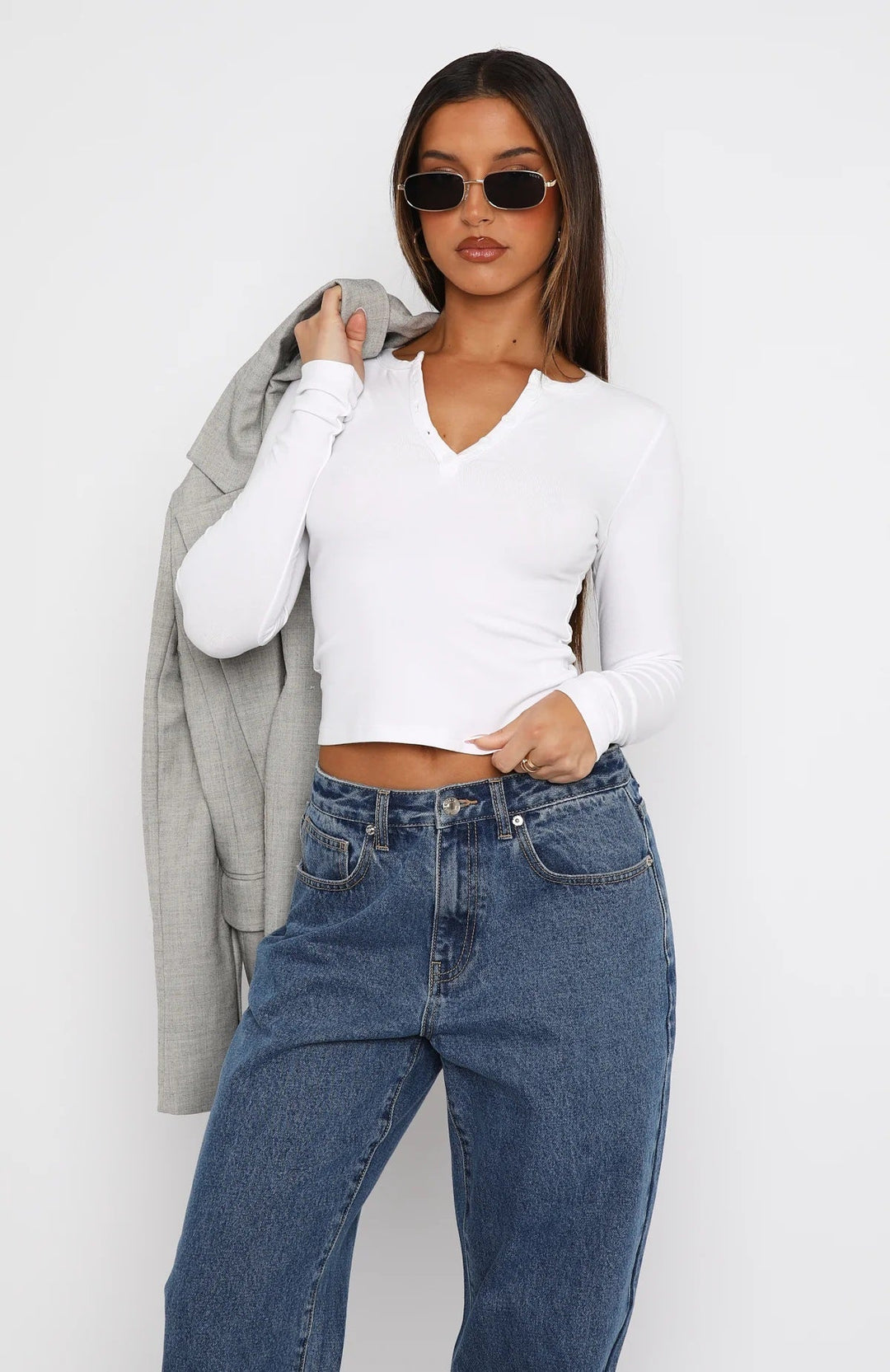 Detalj av den elegante V-halsen på en langermet crop-top for dame. Figurnær og myk stoffkvalitet.