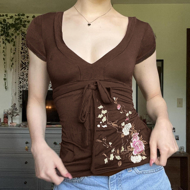 Brun midi-kjole med vakker blomsterbroderi og elegant draperingsdesign. Ideell for fest og hverdag.