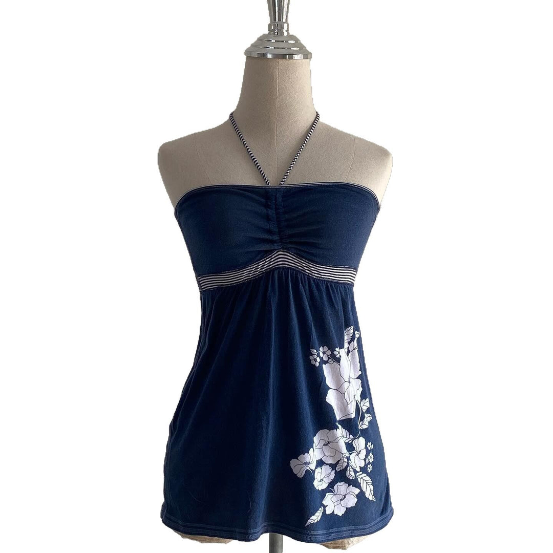 Trendy blå strandtopp for damer med avskåret snitt og blomsterdesign. Kortermet sommertopp for motebevisste.