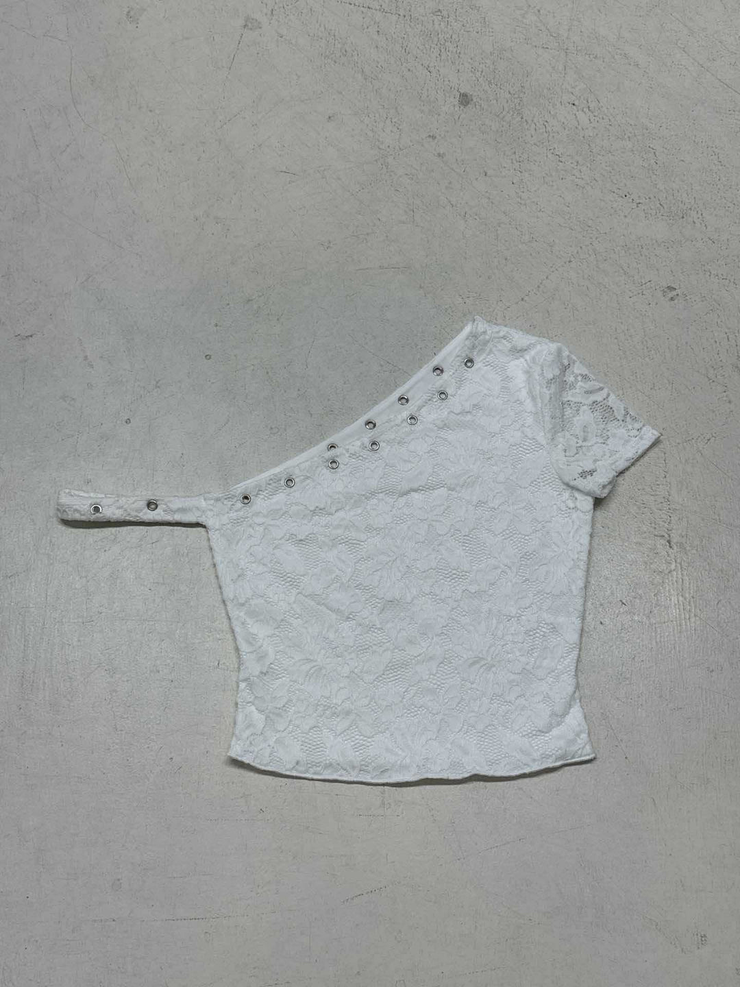 Helbilde av elegant hvit dame topp med korte ermer, unikt asymmetrisk mønster. Perfekt som stilfull festtopp.