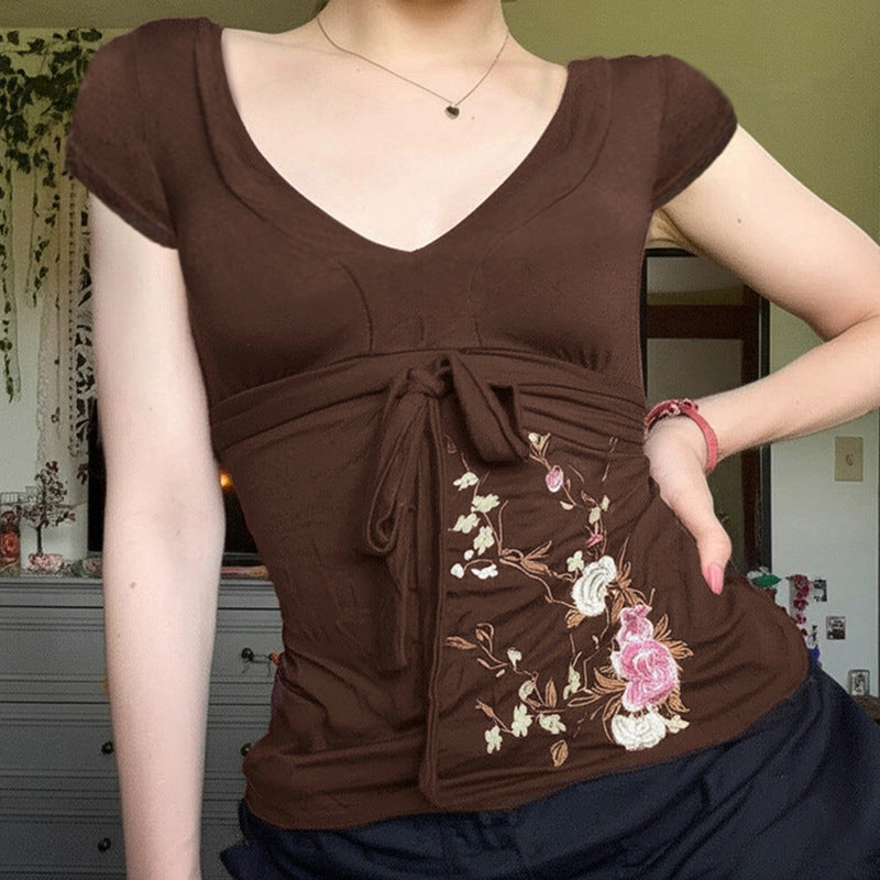 Elegant brun festkjole med blomsterbroderi og smigrende draperingsdesign. Perfekt midi-kjole.