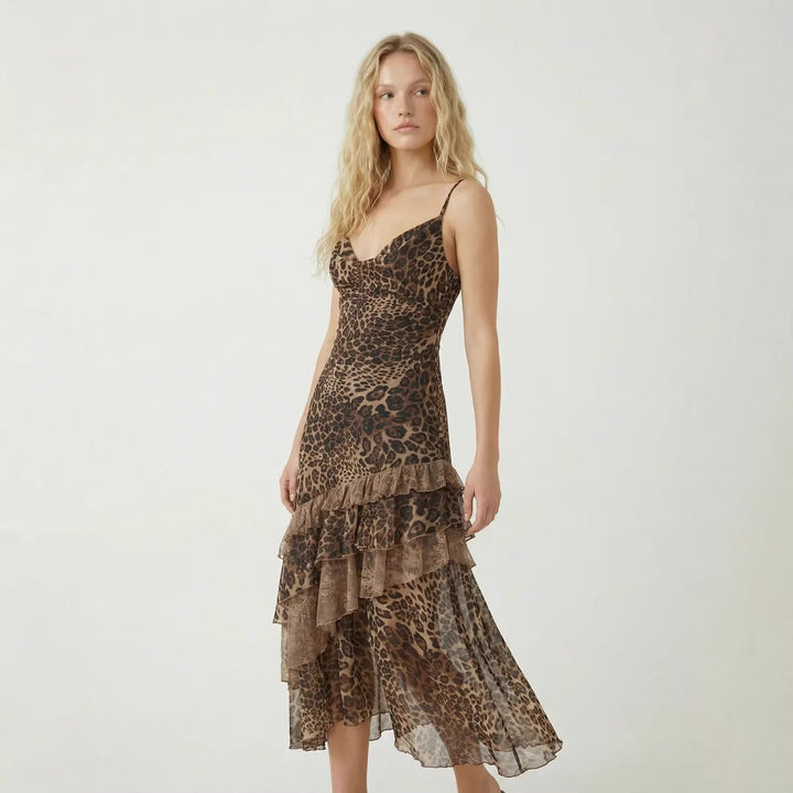 Elegant ermeløs midikjole med leopardprint og asymmetrisk volang for kvinner. Perfekt sommerkjole.