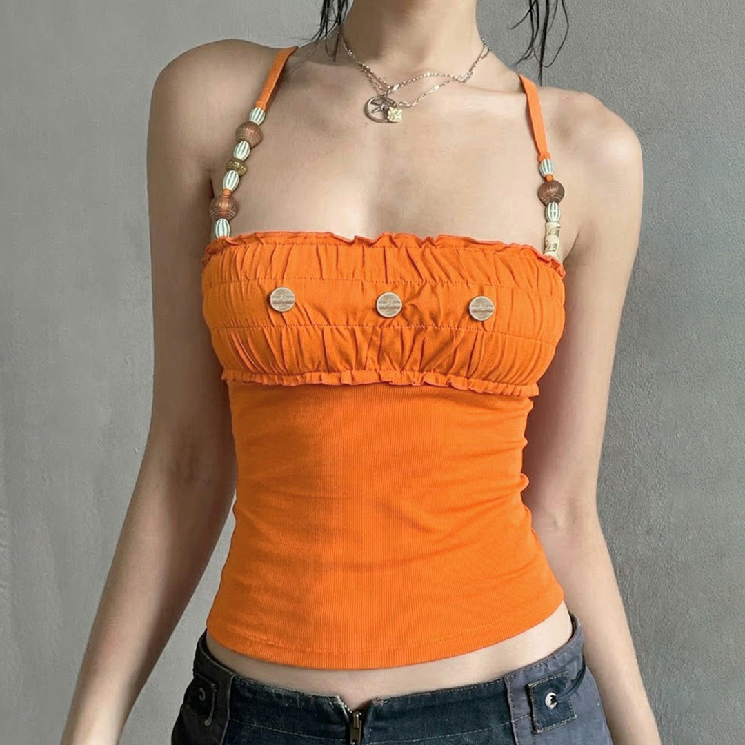 Trendy oransje dametopp med unike stropper, delikate volanger i lett stoff, perfekt for varme dager.