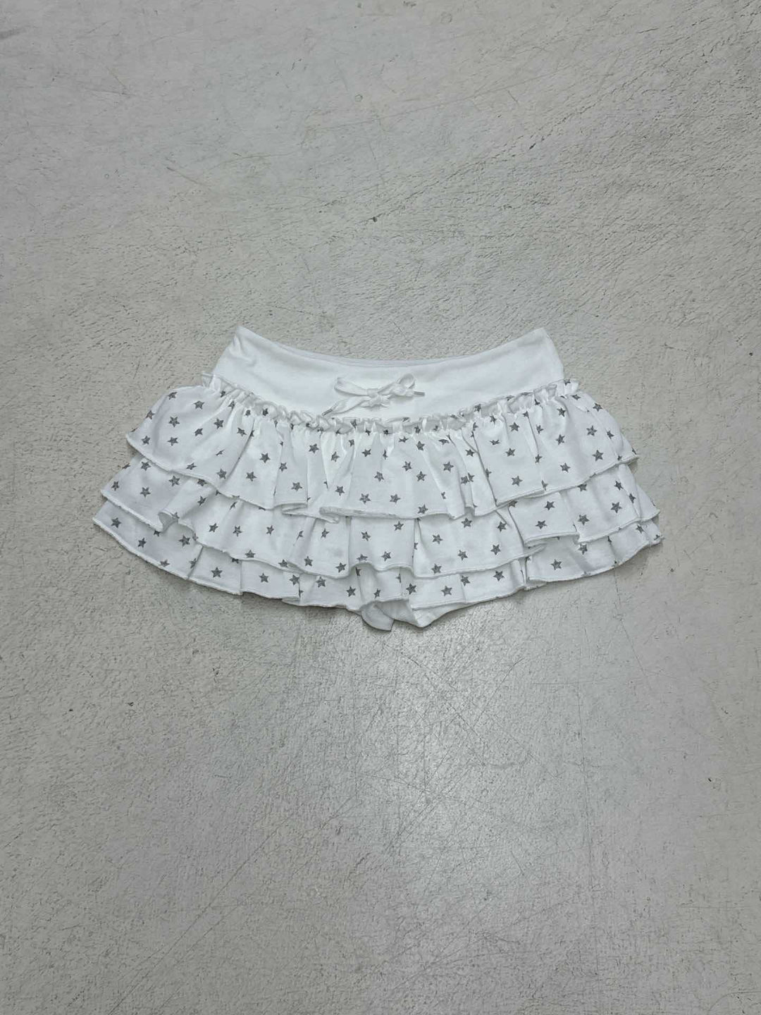 Motebevisst dameskjørt med stjerner og volanger. Trendy a-linje design og elastisk midje, perfekt for sommer.