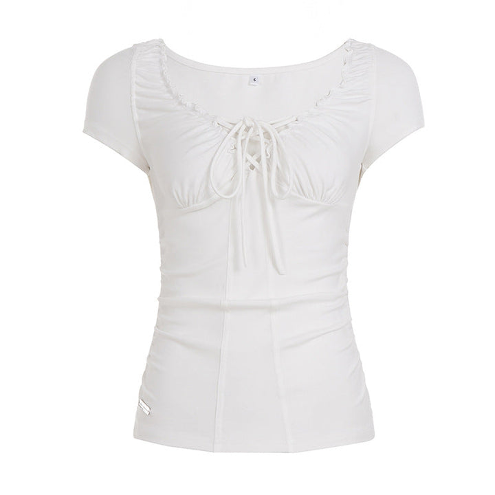 Kortermet dametopp med flatterende snøring i midjen, elegante volanger og behagelig stoff. Hvit og figursydd.