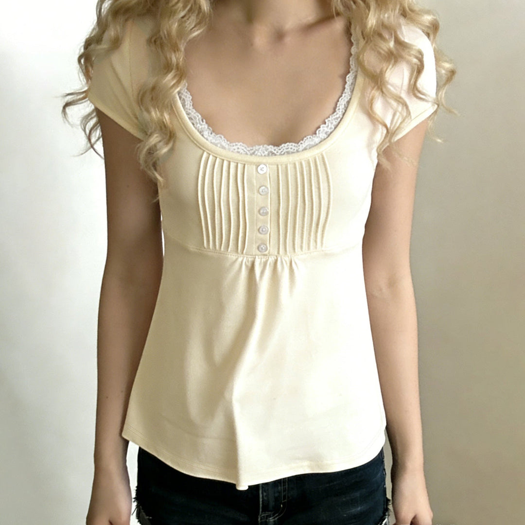 Lysegul kortermet dametopp med rund hals, blonde og knappestolpe. En feminin vår/sommer basic topp.