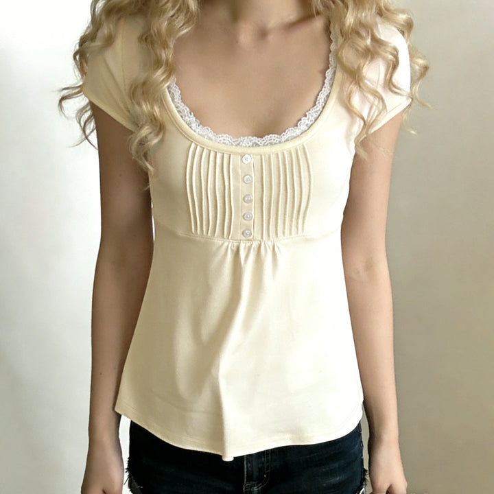 Lysegul kortermet dametopp med rund hals, blonde og knappestolpe. En feminin vår/sommer basic topp.