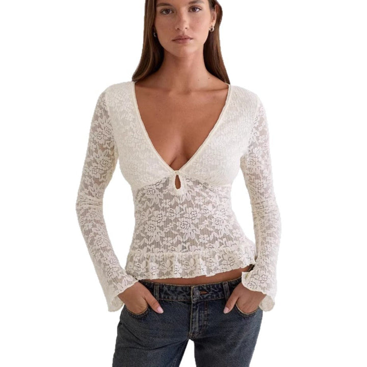 Motebevisst hvit topp med dyp V-hals og feminine volanger, en elegant damebluse for sommerens fester.