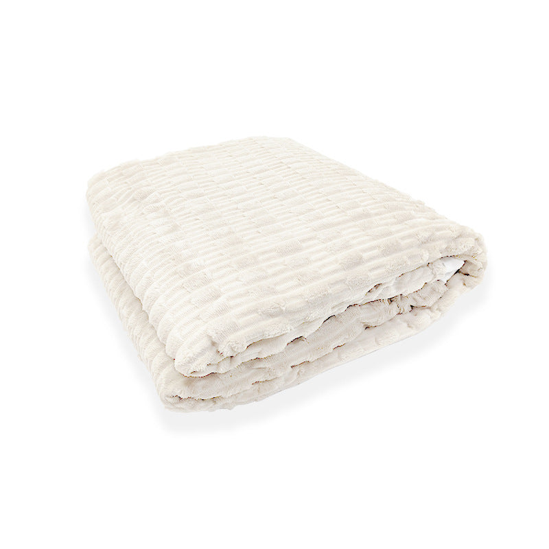 Brettet hvitt fleece teppe, et elegant og mykt innslag i interiøret, perfekt som varmt sofateppe.