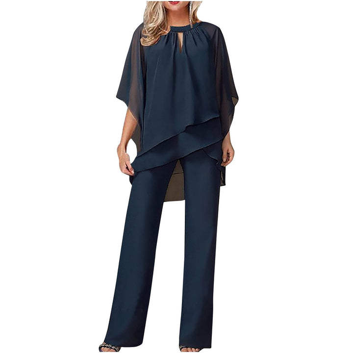 Elegant festantrekk: asymmetrisk topp og brede bukser i et moderne kvinne ensemble.