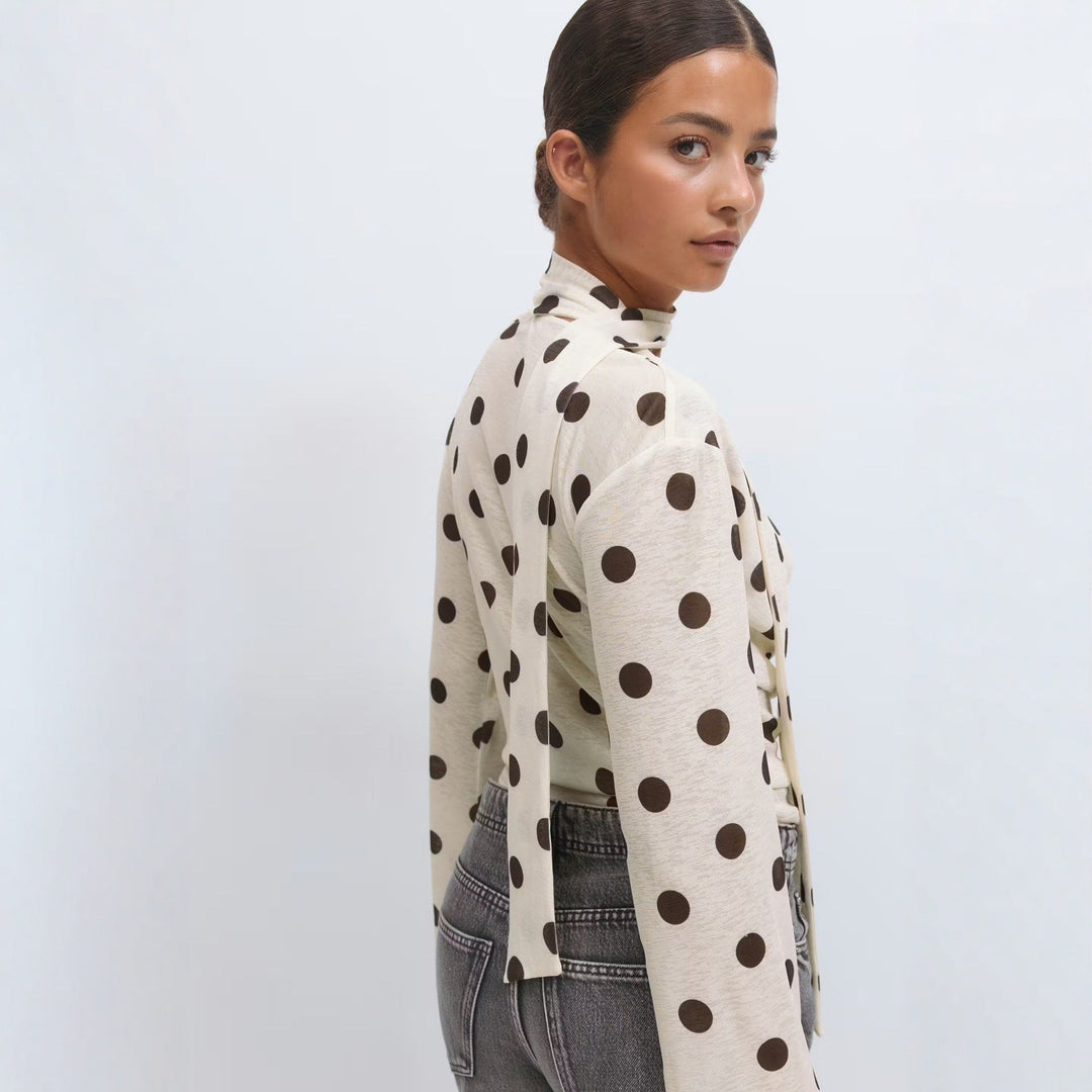 Elegant hvit bluse med sløyfekrage og prikkemønster. Langermet dametopp som passer til både hverdag og fest.
