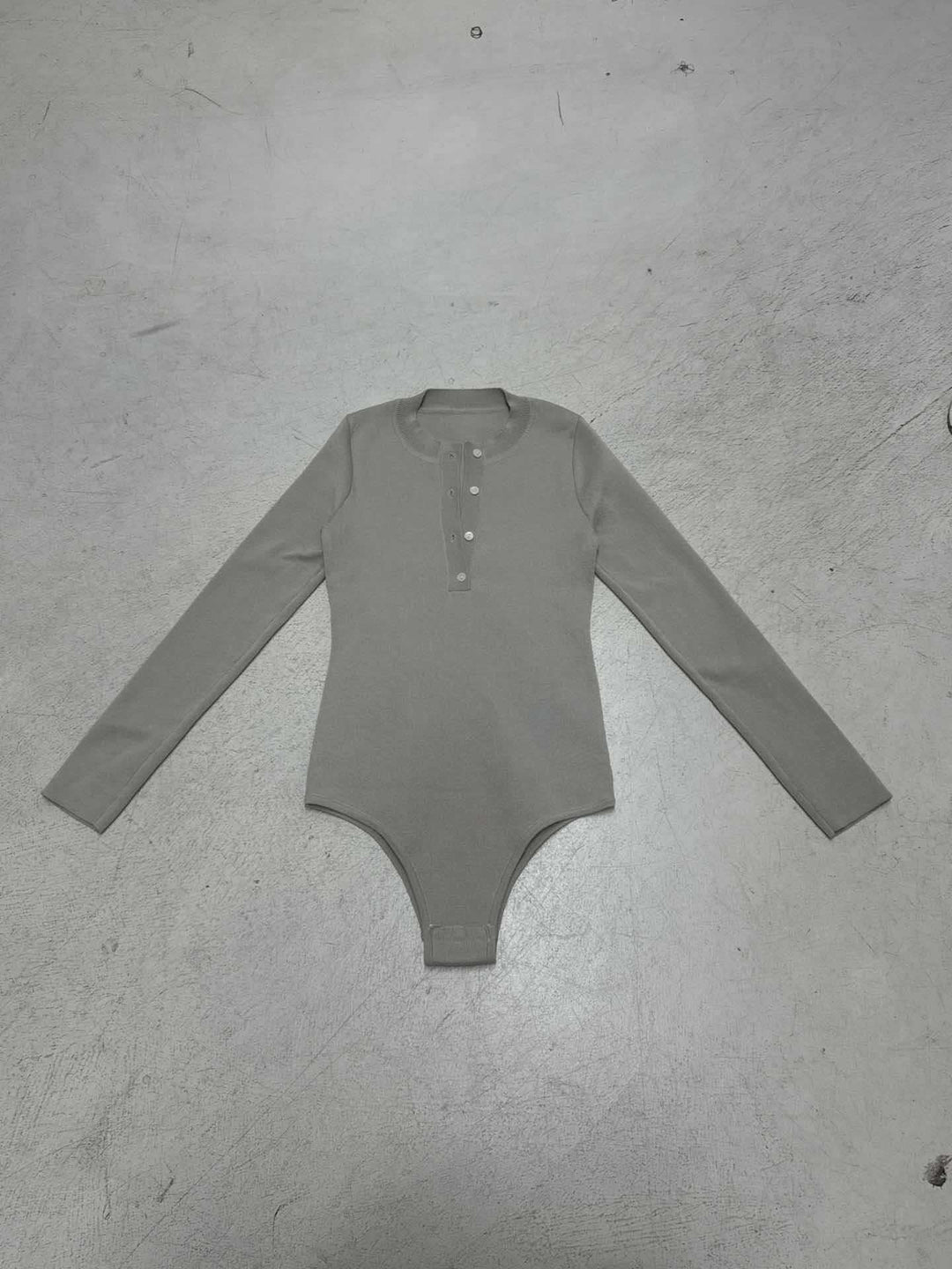 Allsidig khaki ribbet bodysuit med lange ermer og knappeliste, perfekt for et elegant hverdagslook.
