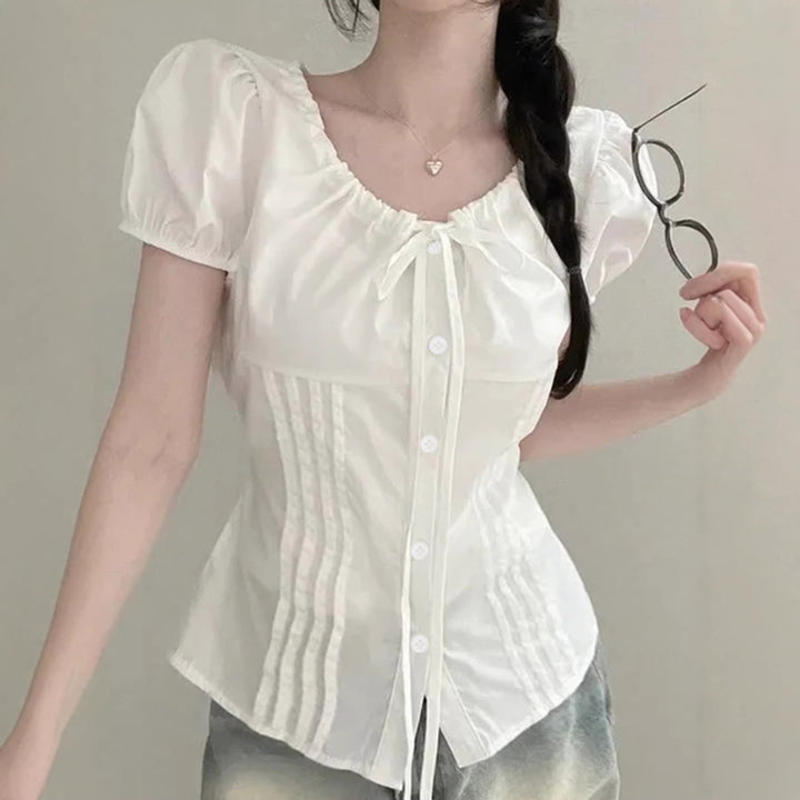 Elegant damebluse med volangdetaljer og figurnær passform i svart, perfekt for kontor og fest.