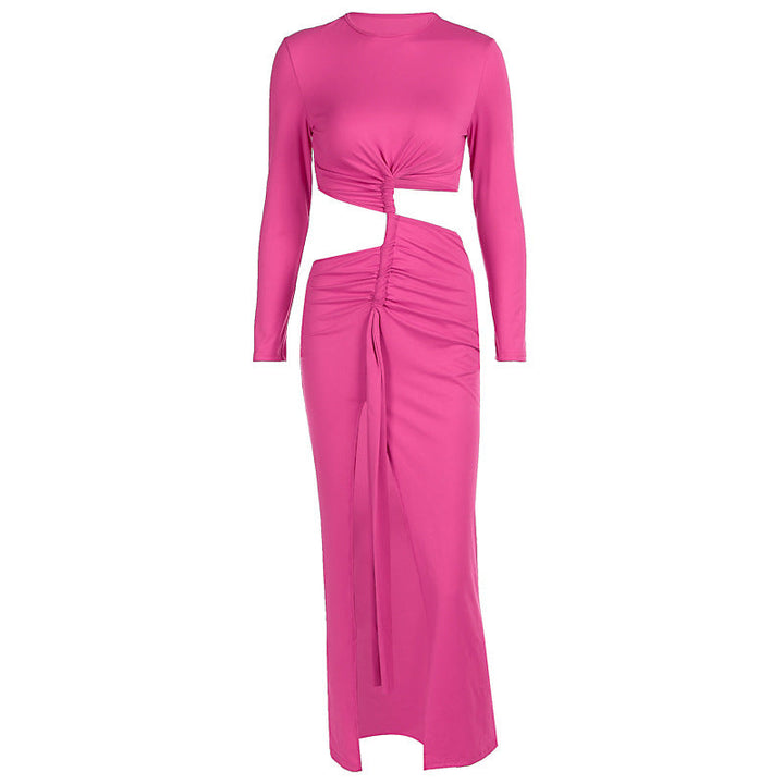 Helkroppsbilde av dame i fuksia omslagskjole med draperinger og cut-out. Et stilfullt kveldsantrekk.