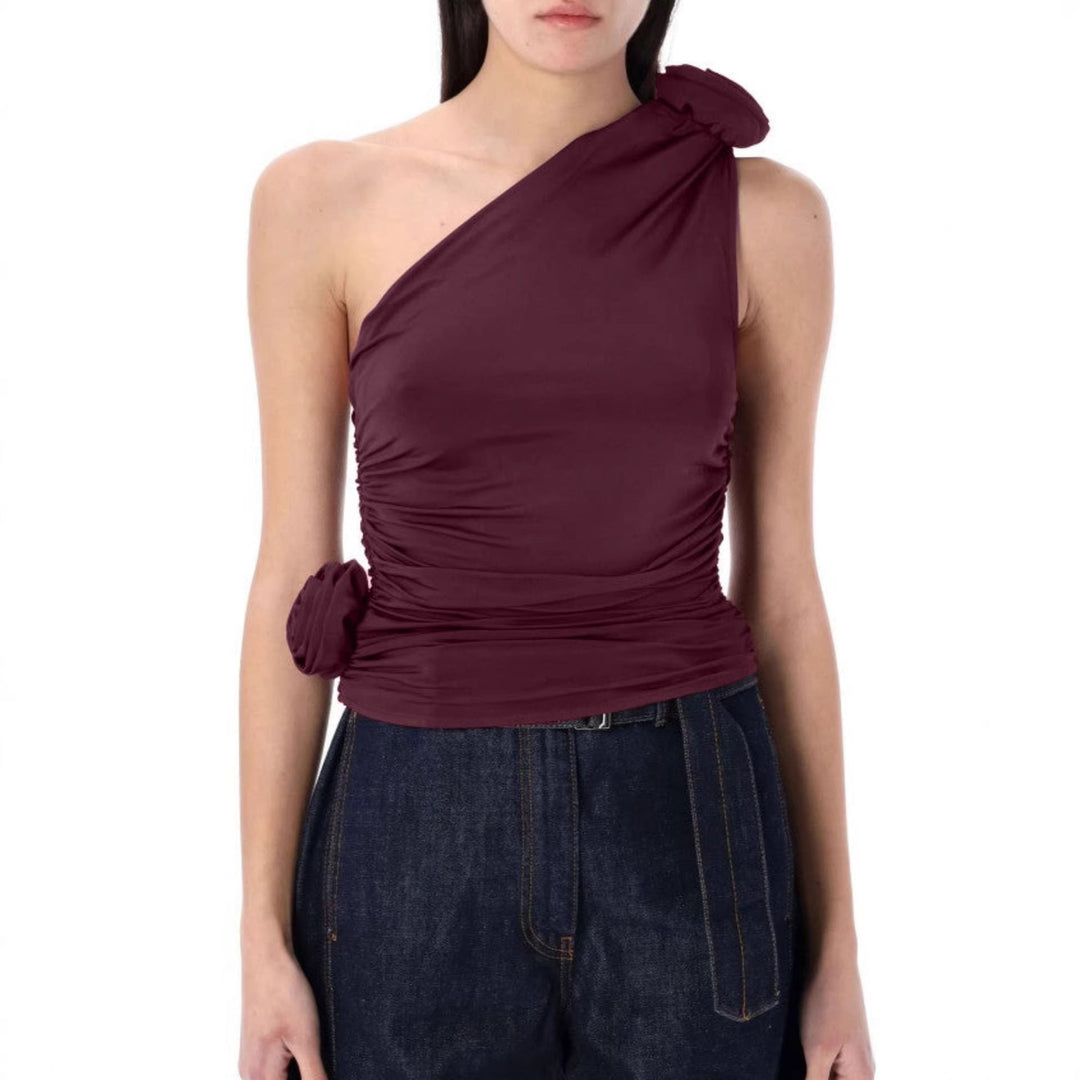 Svart asymmetrisk dametopp med rynker og elegant blomsterdetalj. Moderne festtopp for sommer.