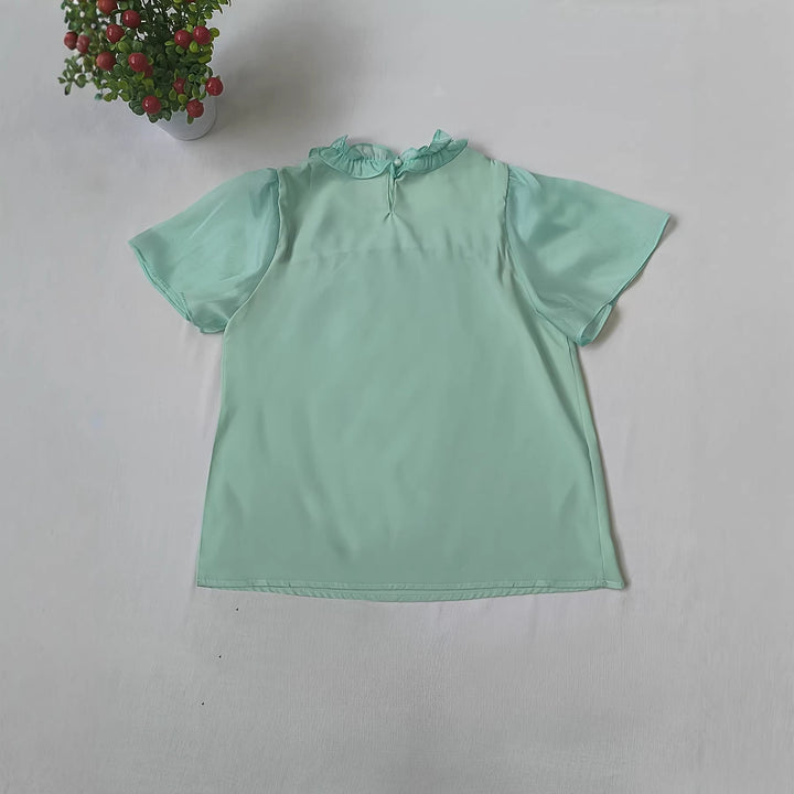 Moteriktig mintgrønn damebluse med volanger og transparente ermer, en trendy festtopp eller kontorantrekk.