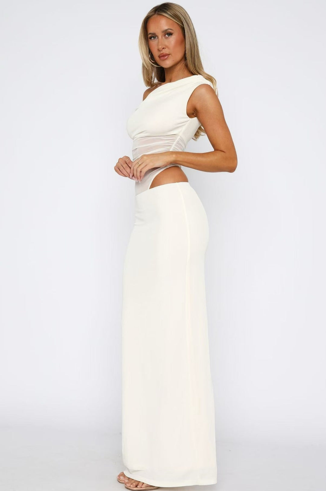 Elegant damekjole med asymmetrisk skjørt, transparente innslag, lang og flytende, egnet for aften og fest.