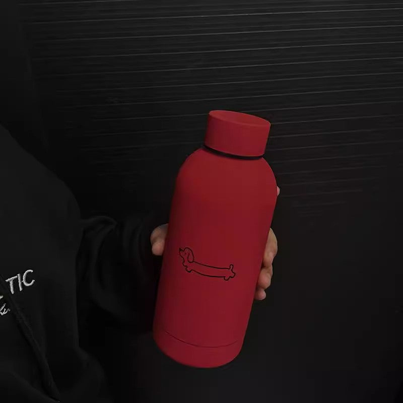 Svart stålflaske termos med hundemotiv. Robust isolert drikkeflaske unisex, perfekt til tur og kontor.