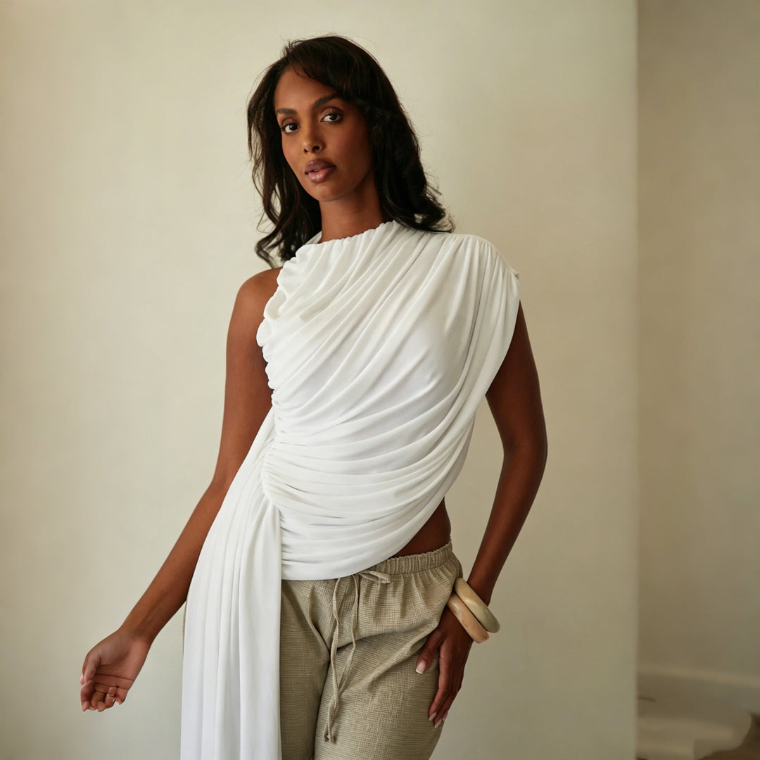 Elegant dametopp med asymmetrisk snitt og stilfulle draperinger, perfekt for fest og hverdagsbruk.