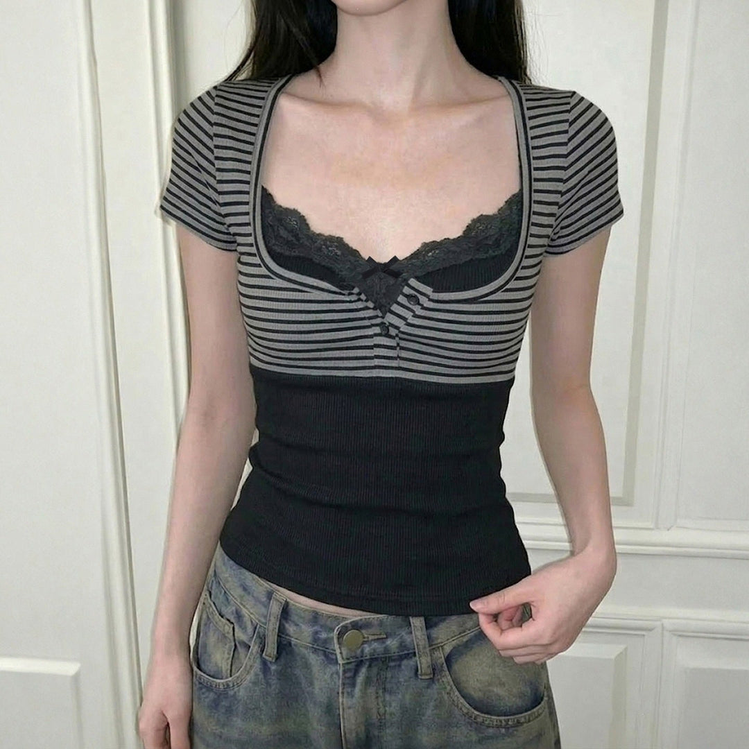 Elegant kortermet bluse til dame i mørkegrå med trendy lagdelt look og unike spissdetaljer.