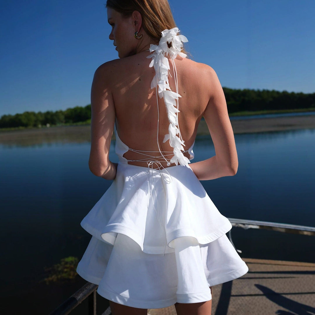 Hvit damekjole med voluminøst skjørt og elegant halterneck. En mote-favoritt for sommer og spesielle anledninger.