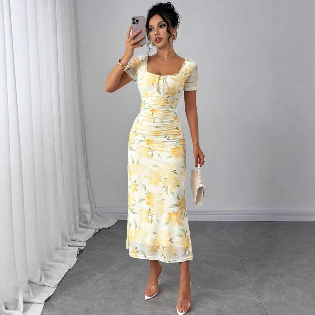 Elegant dame midi-kjole med levende blomsterprint, firkantet utringning og flytende folder, perfekt for sommerfest.