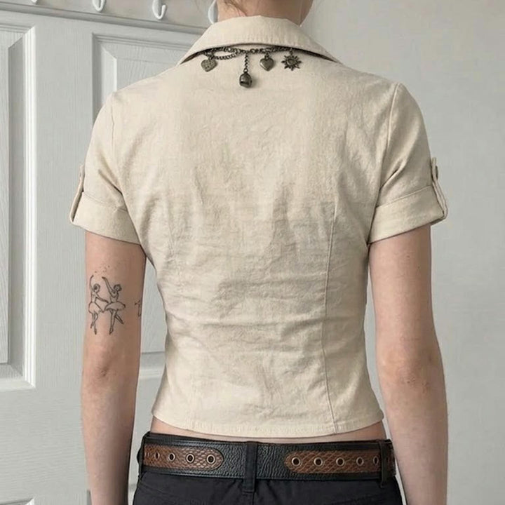 Kortermet khaki dametopp, figursydd passform med stilrene knapper, flott for en moderne hverdagslook.
