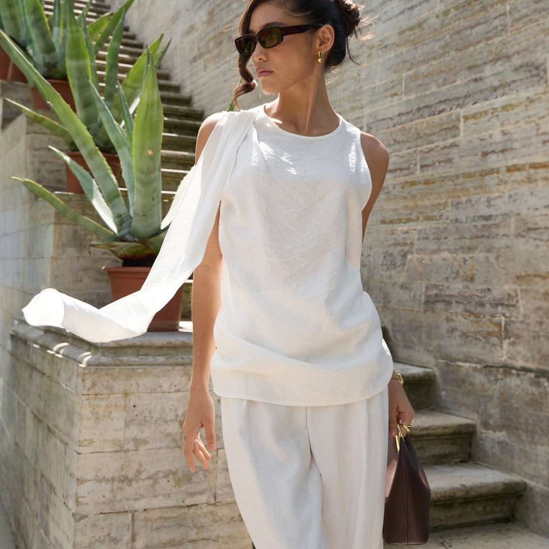 Hvit elegant asymmetrisk topp for dame, perfekt for vår og sommer.