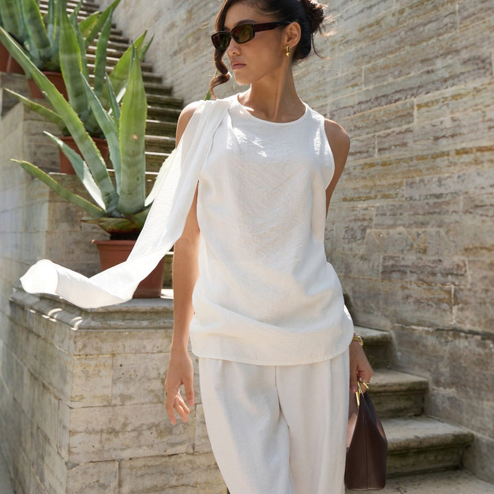 Hvit elegant asymmetrisk topp for dame, perfekt for vår og sommer.