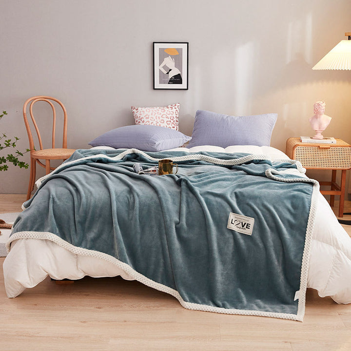 Fluffy kosepledd til dame med lekne sky-detaljer. Mykt og varmt for avslappende øyeblikk på sofaen.