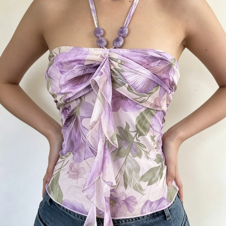 Feminin blomstret topp med spaghettistropper for dame. Volanger gir et luftig og sommerlig uttrykk.