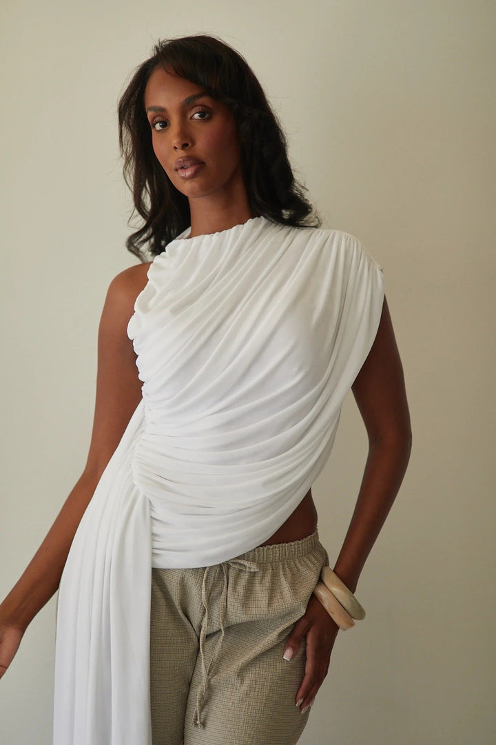 Moderne elegant asymmetrisk dametopp med strategisk plasserte draperinger for en slank silhuett.