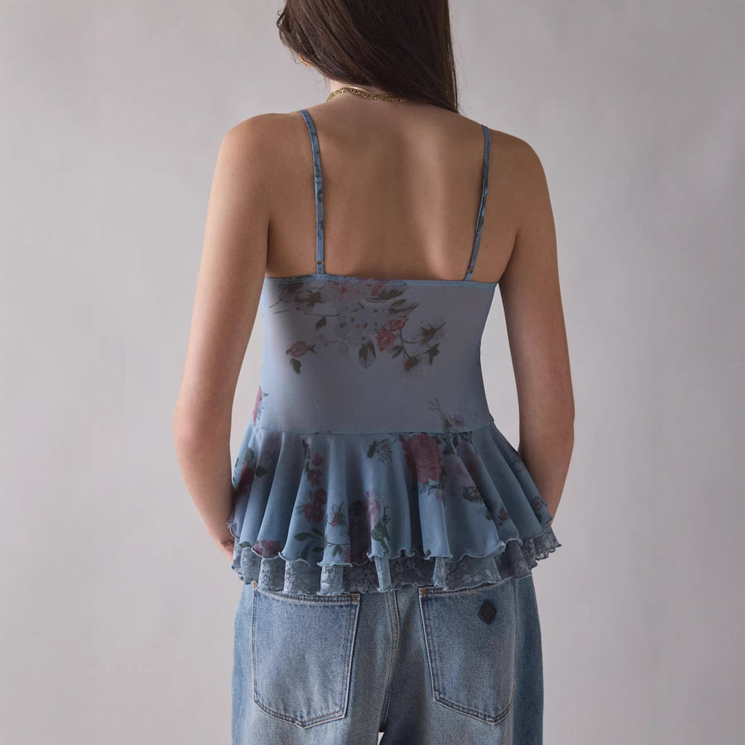 Stilig damebluse med volanger, blondedetaljer og tynne, justerbare stropper. Tilgjengelig i korall og lavendel.