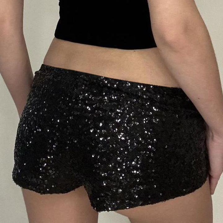 Nærbilde av figurnære svarte shorts, fremhever nagler og funksjonelle sidelommer for en kul stil.