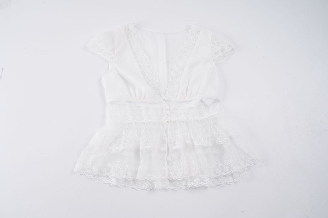 Chic hvit volangtopp med dyp V-hals og feminine detaljer, en elegant tillegg til kvinnemoten.