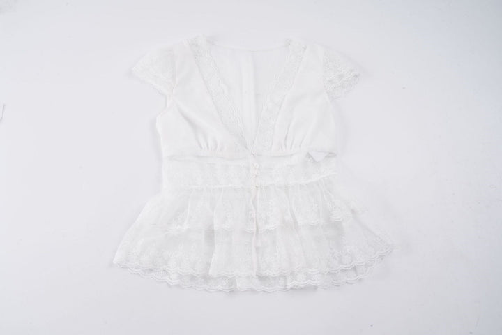 Chic hvit volangtopp med dyp V-hals og feminine detaljer, en elegant tillegg til kvinnemoten.